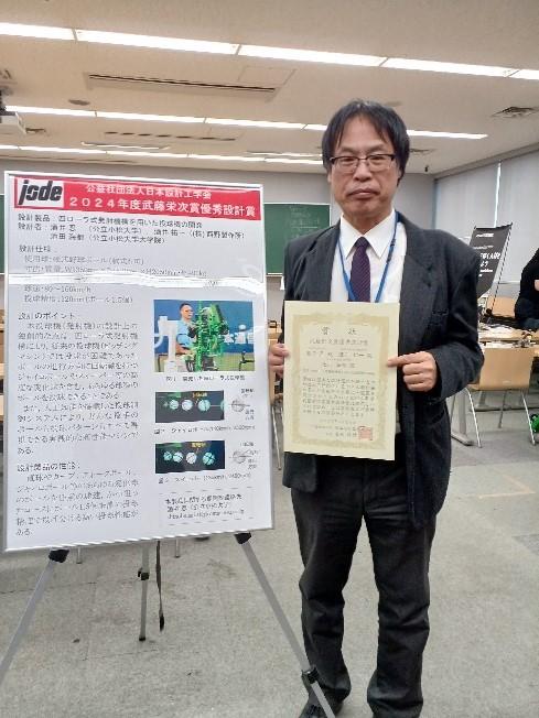 四ローラ式投球機のポスターと酒井忍教授.jpg